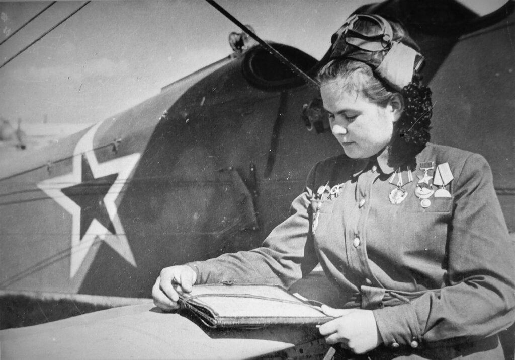Navigator Yekaterina Ryabova beside a Po-2 biplane